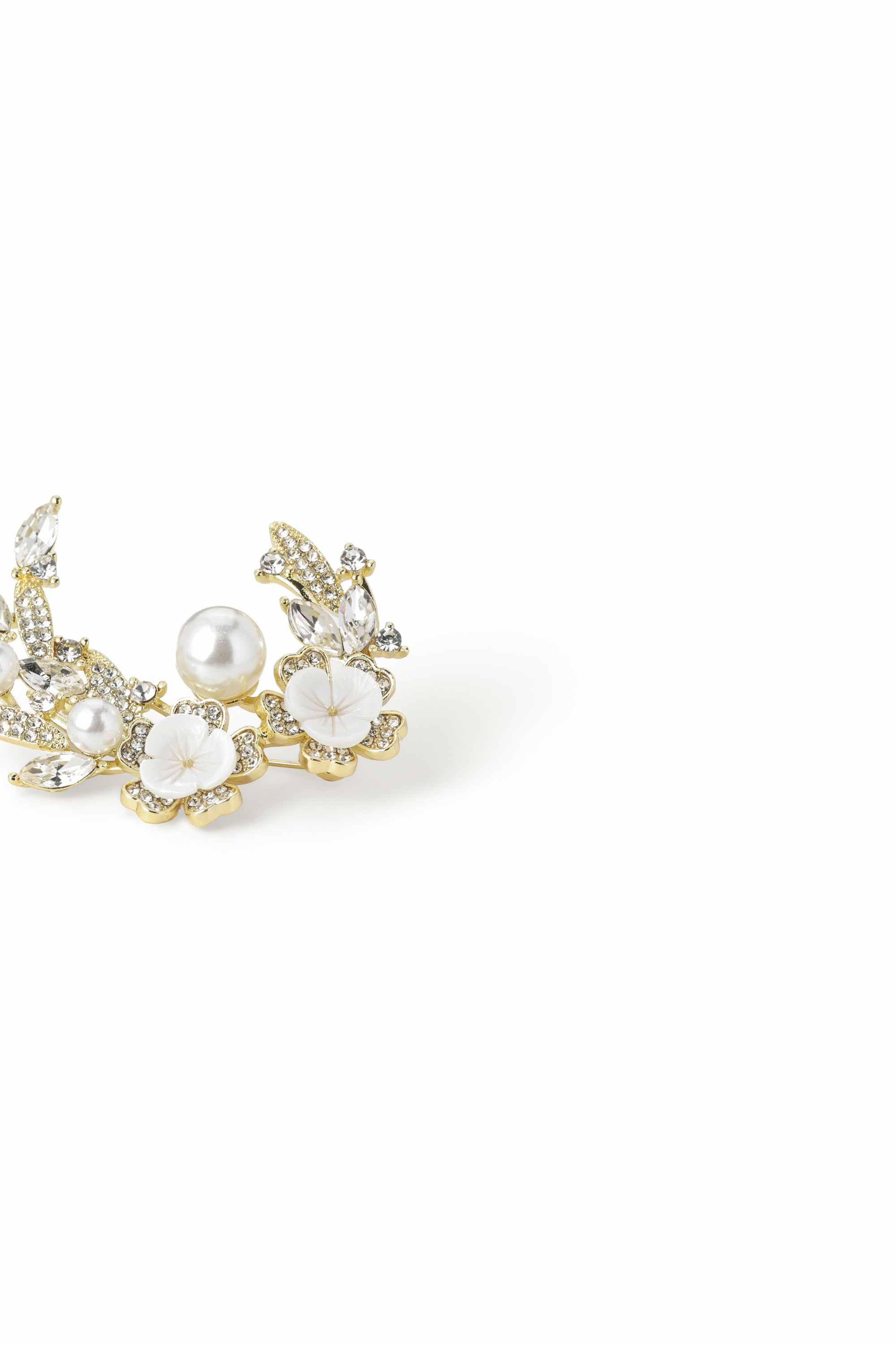 Side view of the Aiko Tanaka Shiro no Kage gold crescent pearl brooch with mother-of-pearl blossoms, on a white background