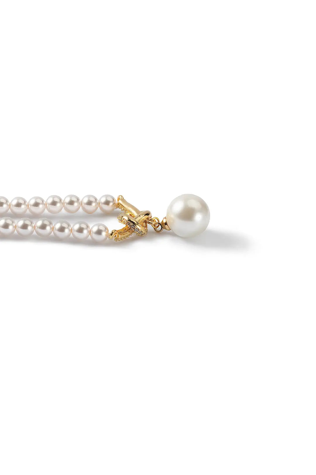 Close-up of the Aiko Tanaka Shizuku no Chigiri gold toggle clasp holding a large white pearl, on white