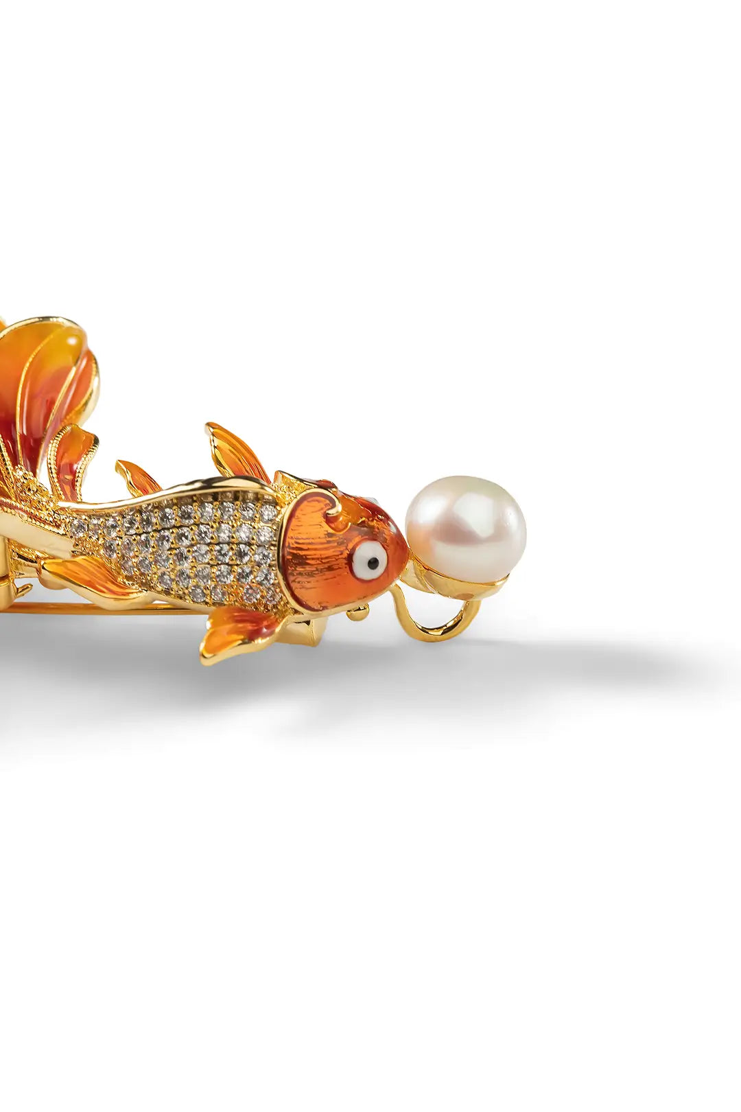 Aiko Tanaka Kasane brooch, an orange enamel goldfish with crystal scales holding a white pearl, shown on a white background