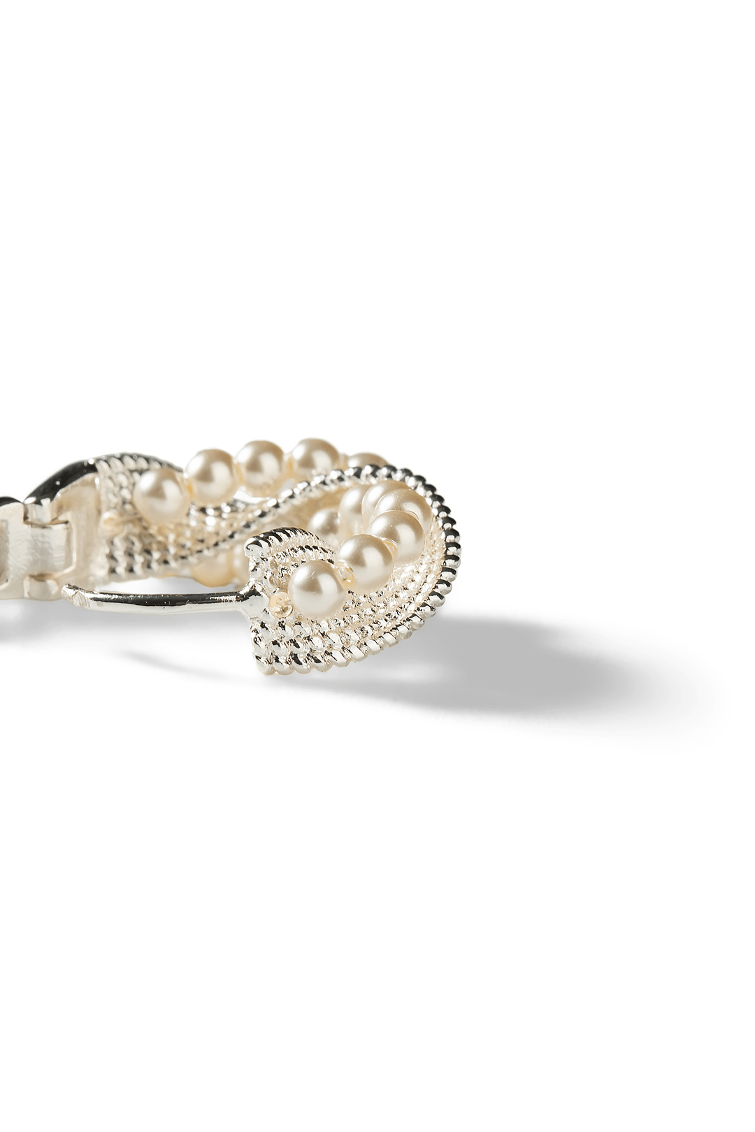 Aiko Tanaka Shiranami earring side view, a curved silver hoop lined with small pearls and crystals, white background