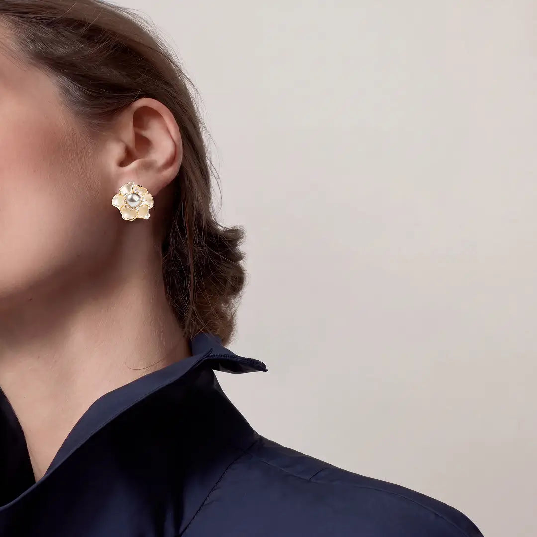 Woman in a navy collar wearing an Aiko Tanaka Koharu shell flower earring with a pearl center, side view