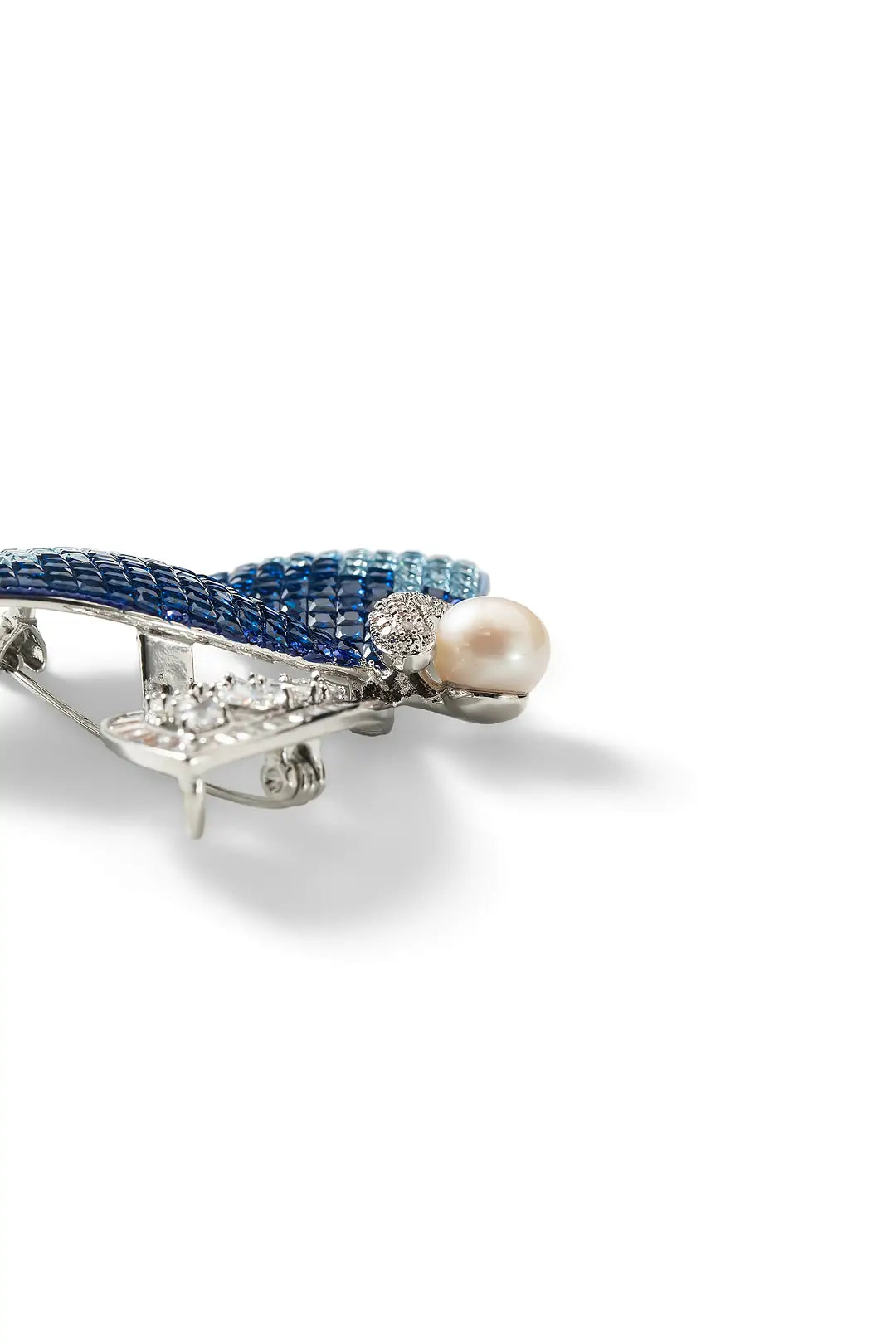Aiko Tanaka Ageha brooch side view, a blue pavé crystal butterfly wing with a white pearl accent, white background