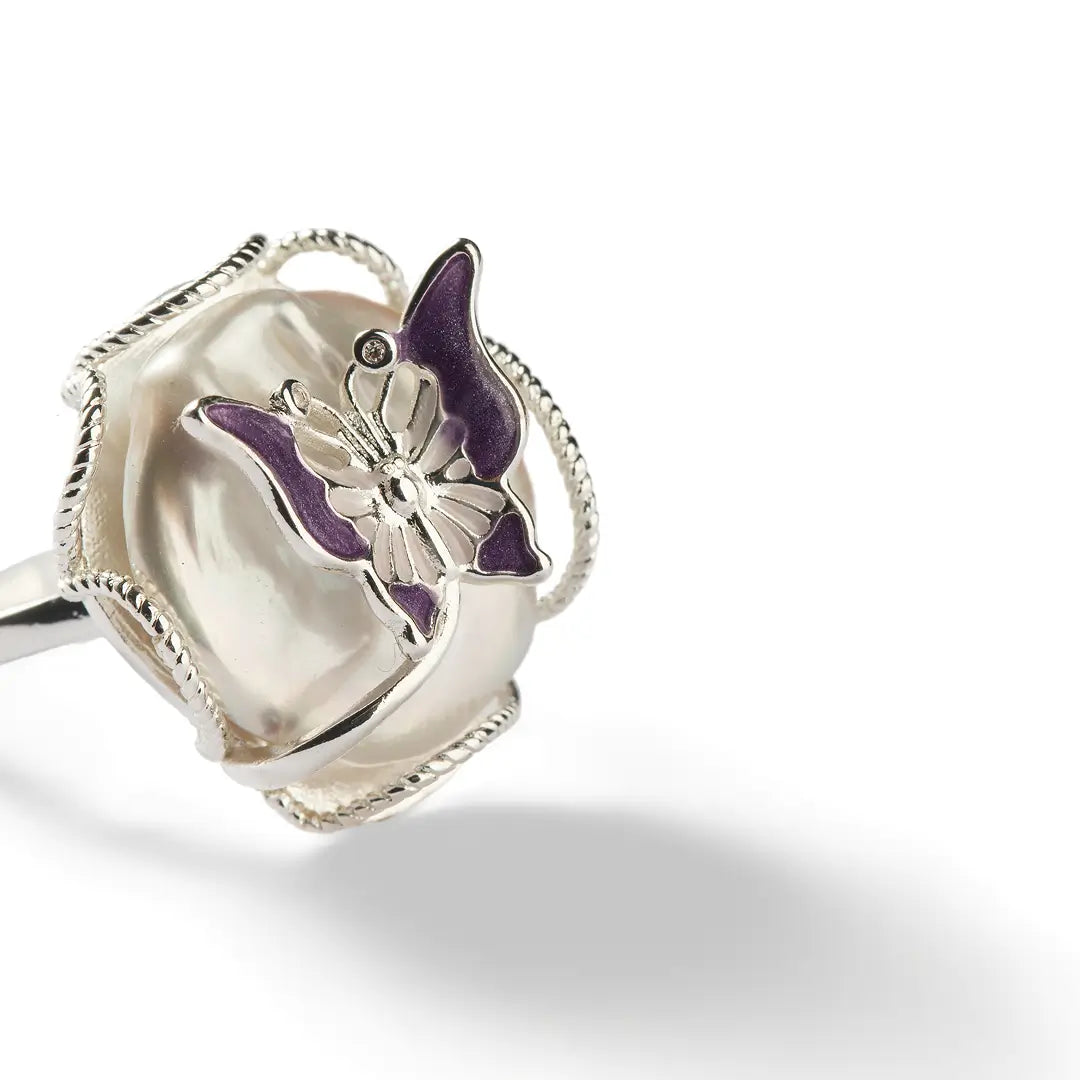Close-up of the Aiko Tanaka Casane ring showing its silver wave setting and purple enamel accent, on white