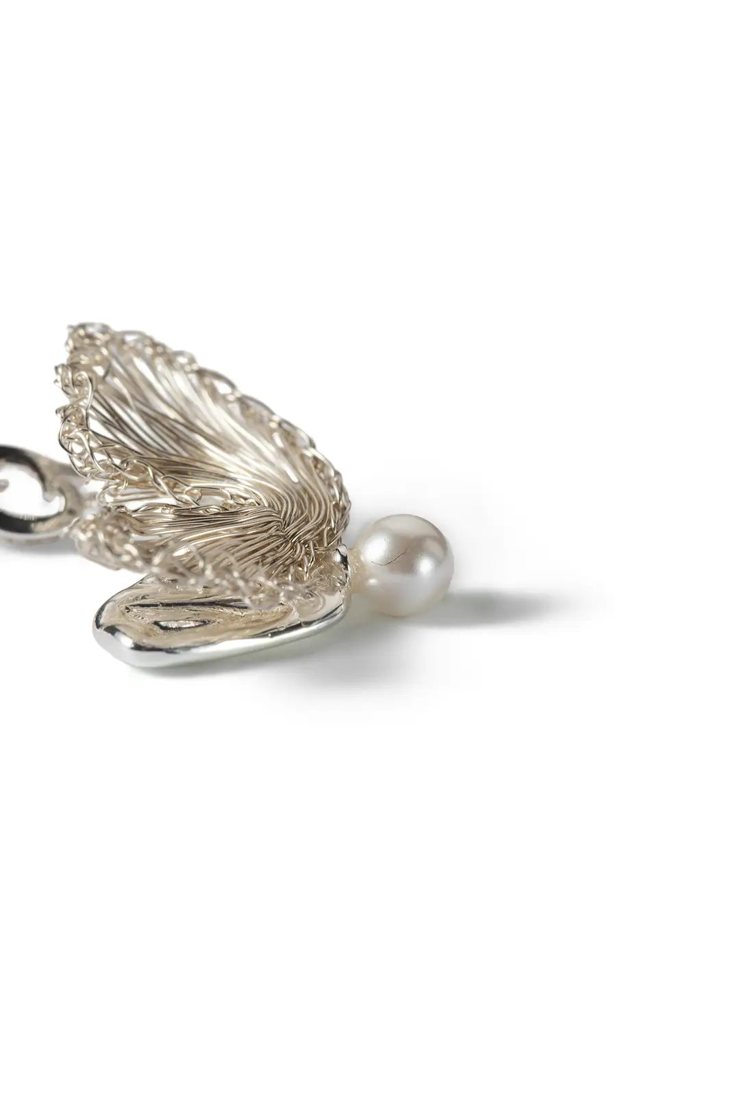 Aiko Tanaka Hakucho necklace pendant close-up, a textured silver wing with a white pearl, on a white background