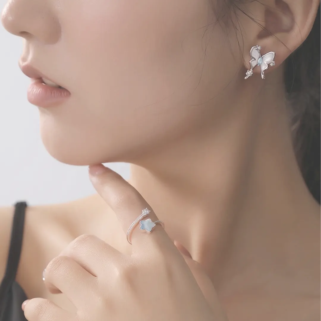 Profile of a woman wearing the Aiko Tanaka Hakuyo silver butterfly stud earring with her hand at her chin