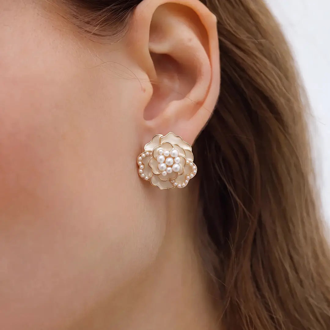 Aiko Tanaka Hanakage earrings, a pale pink crystal rose stud, worn on the ear of a model with hair tucked back