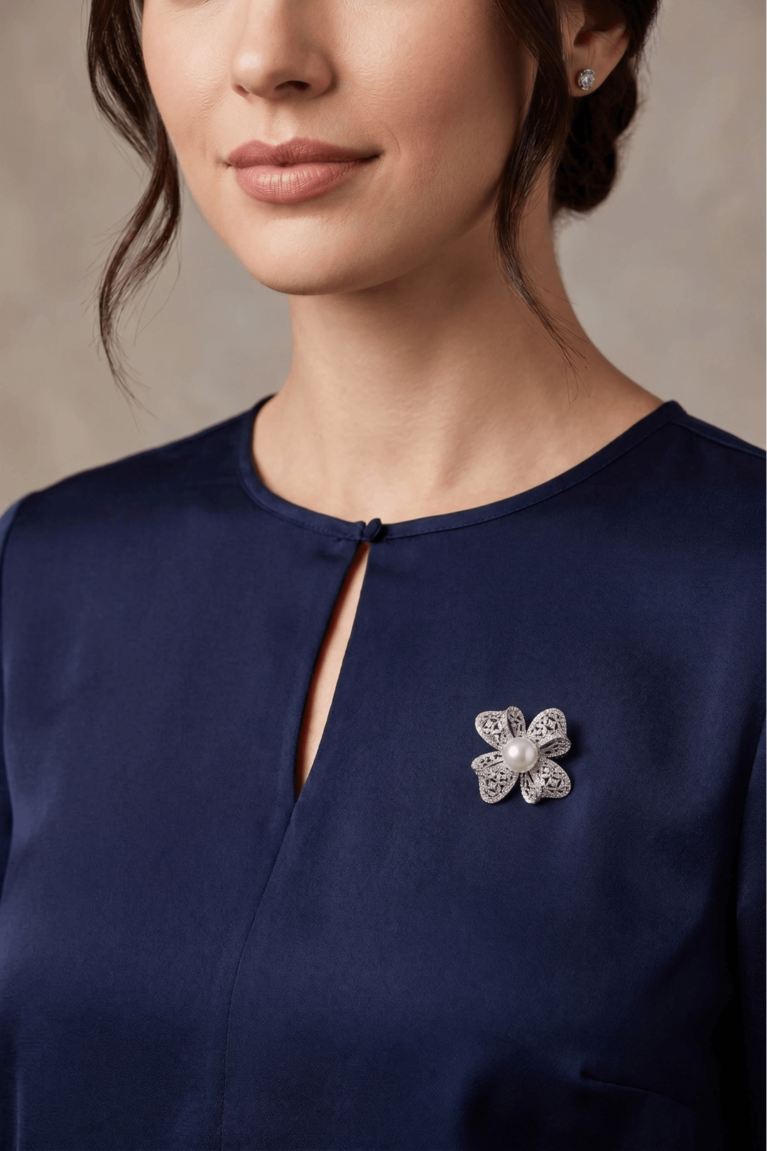 Woman in a navy keyhole-neck top wearing the Aiko Tanaka Hikari no Hana silver crystal and pearl flower brooch