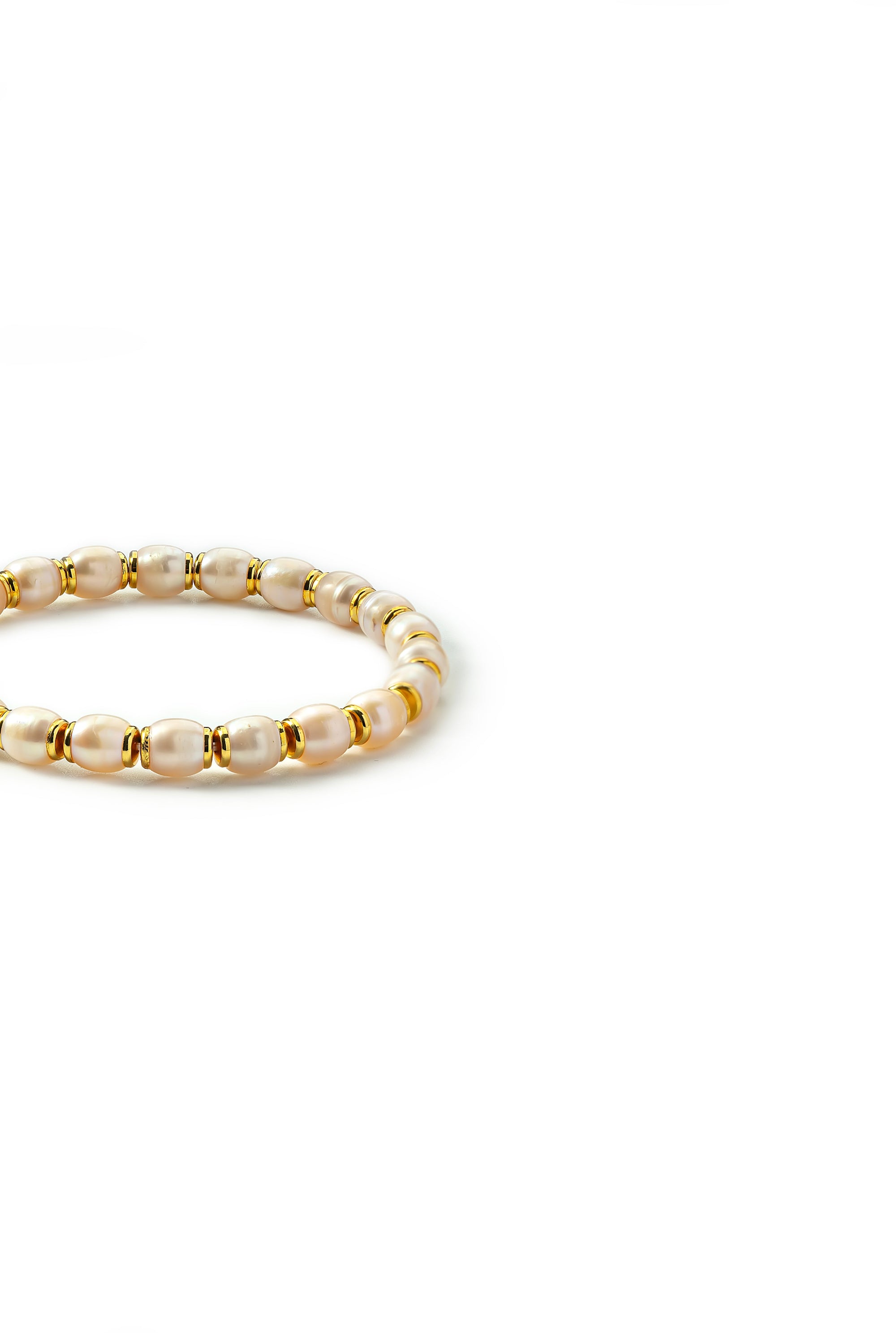 Side view of the Aiko Tanaka Hinata bracelet of white pearls alternating with tiny gold beads, on a white background