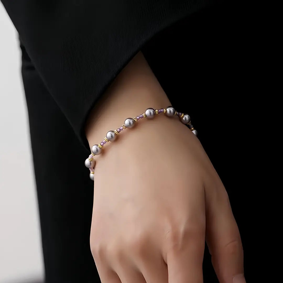 Aiko Tanaka Kasumi no Ito bracelet, silver-grey pearls on a fine chain, worn on the wrist against a black top