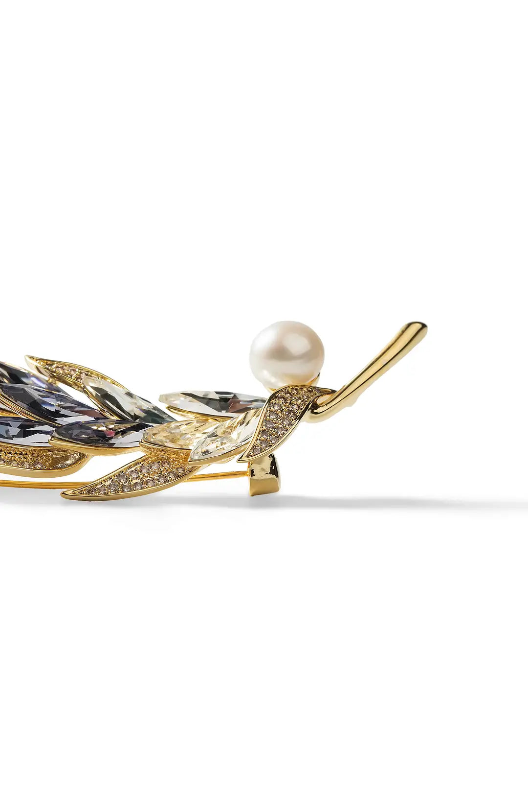 Aiko Tanaka Kazahana brooch, a gold feather with violet crystal fronds and a white pearl, angled on white