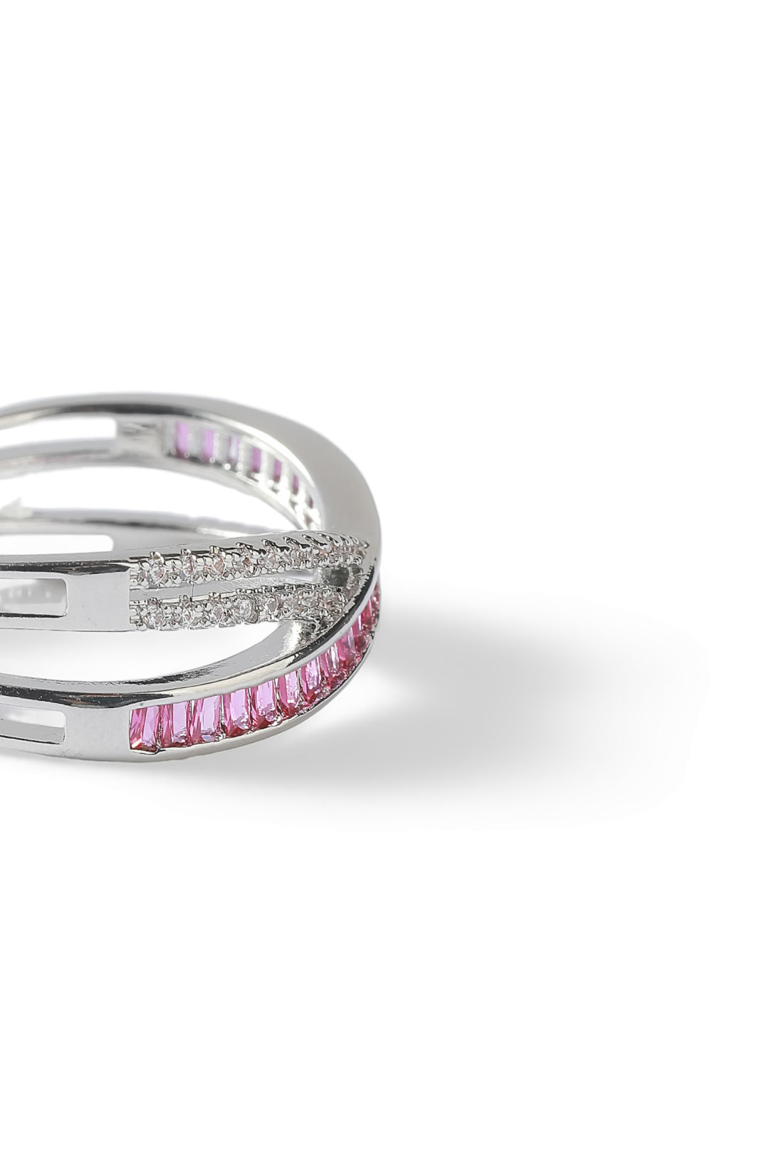 Aiko Tanaka Kosa silver crossover ring with a row of pink stones and pave crystals, angled view on white