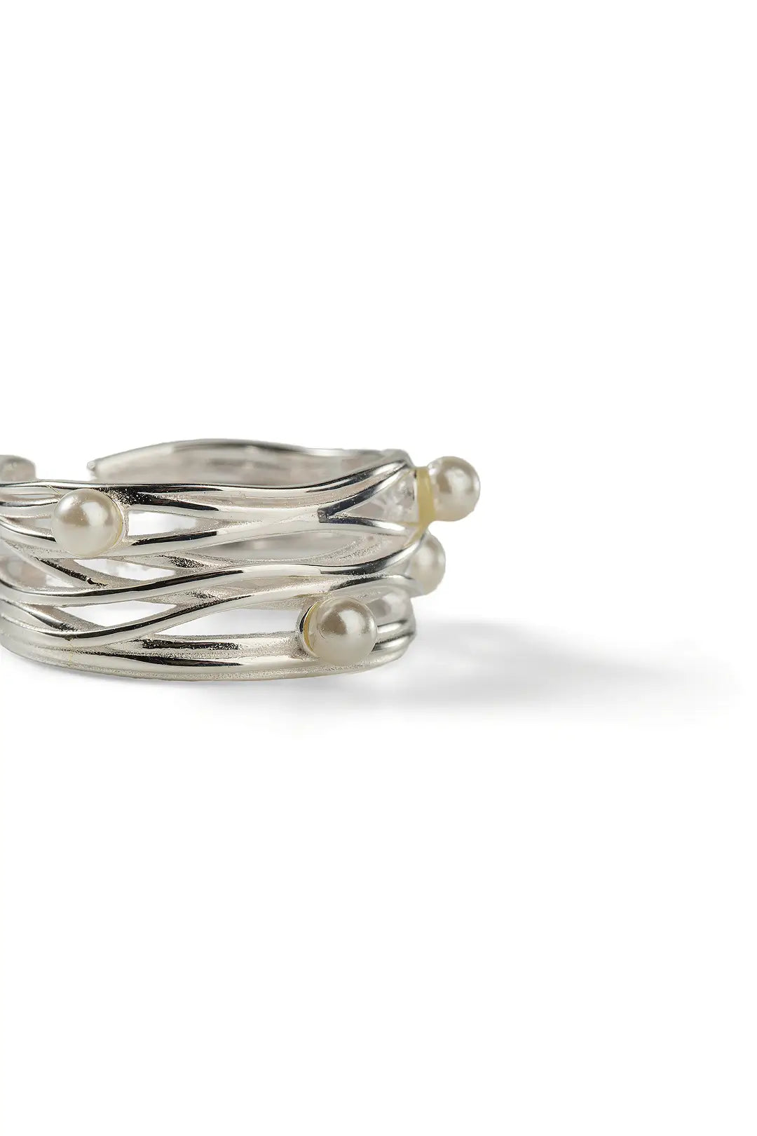 Aiko Tanaka Meguri ring, stacked silver bands woven together with small white pearls, shown on a white background