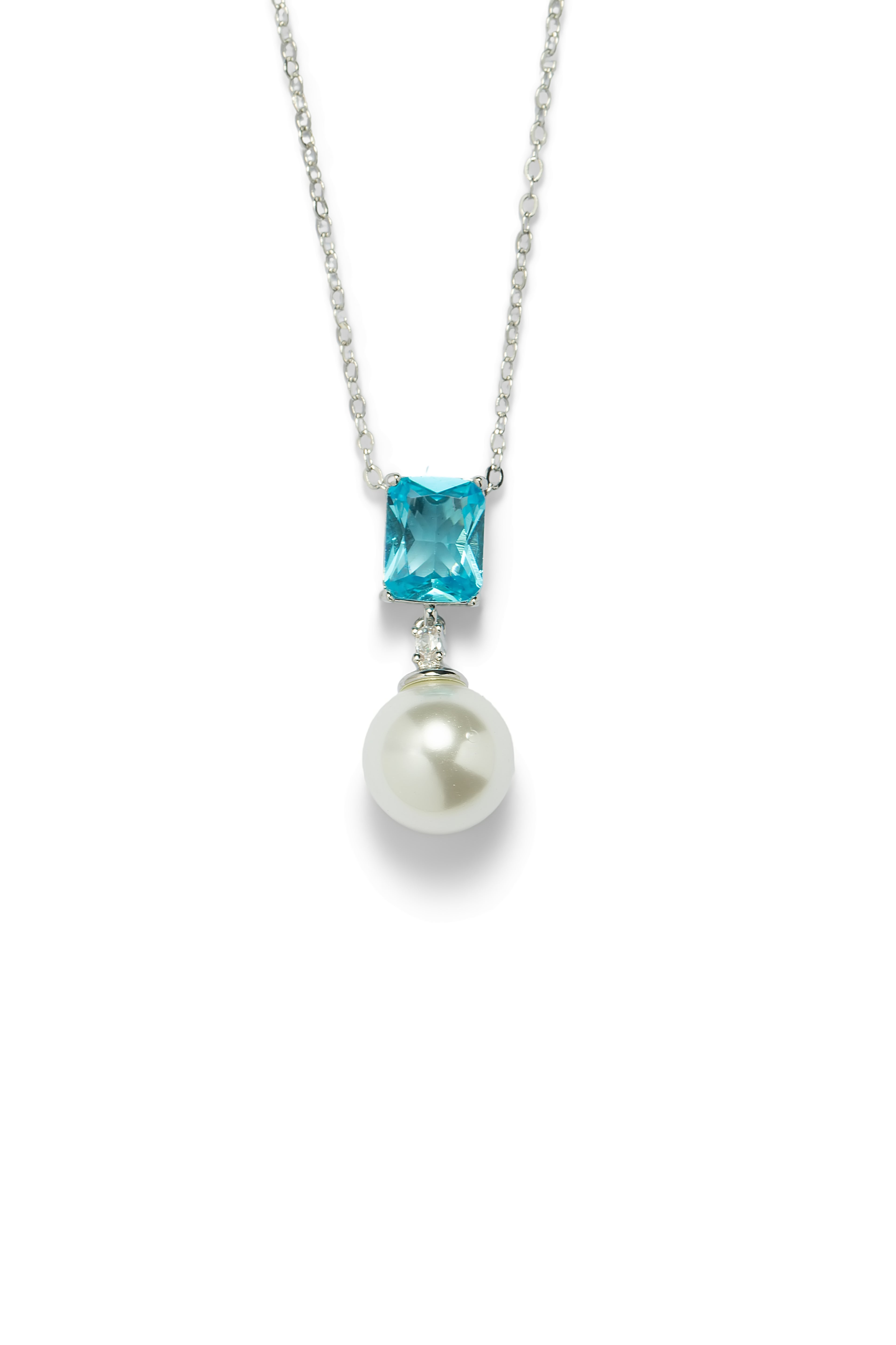 Aiko Tanaka Mizu Fracture pearl necklace with aqua blue stone pendant, worn by a woman in a navy knit top outdoors