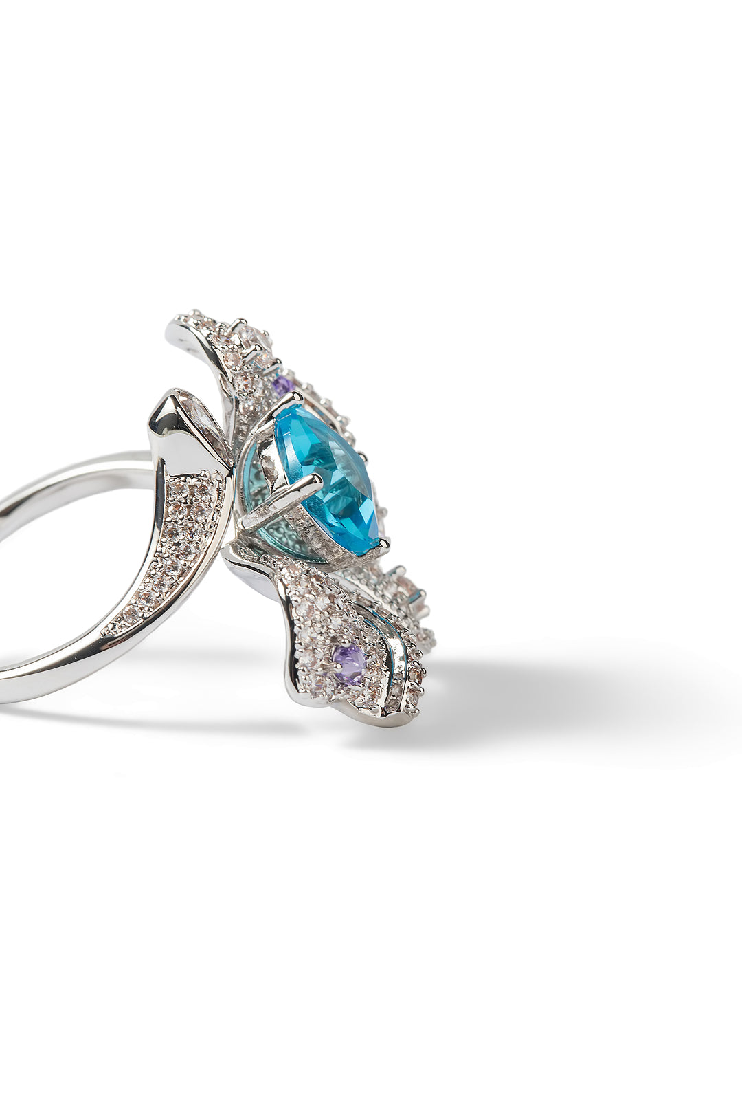Side view of the Aiko Tanaka Mizu no Ran silver orchid ring with an aqua stone and lilac crystal petals, on white