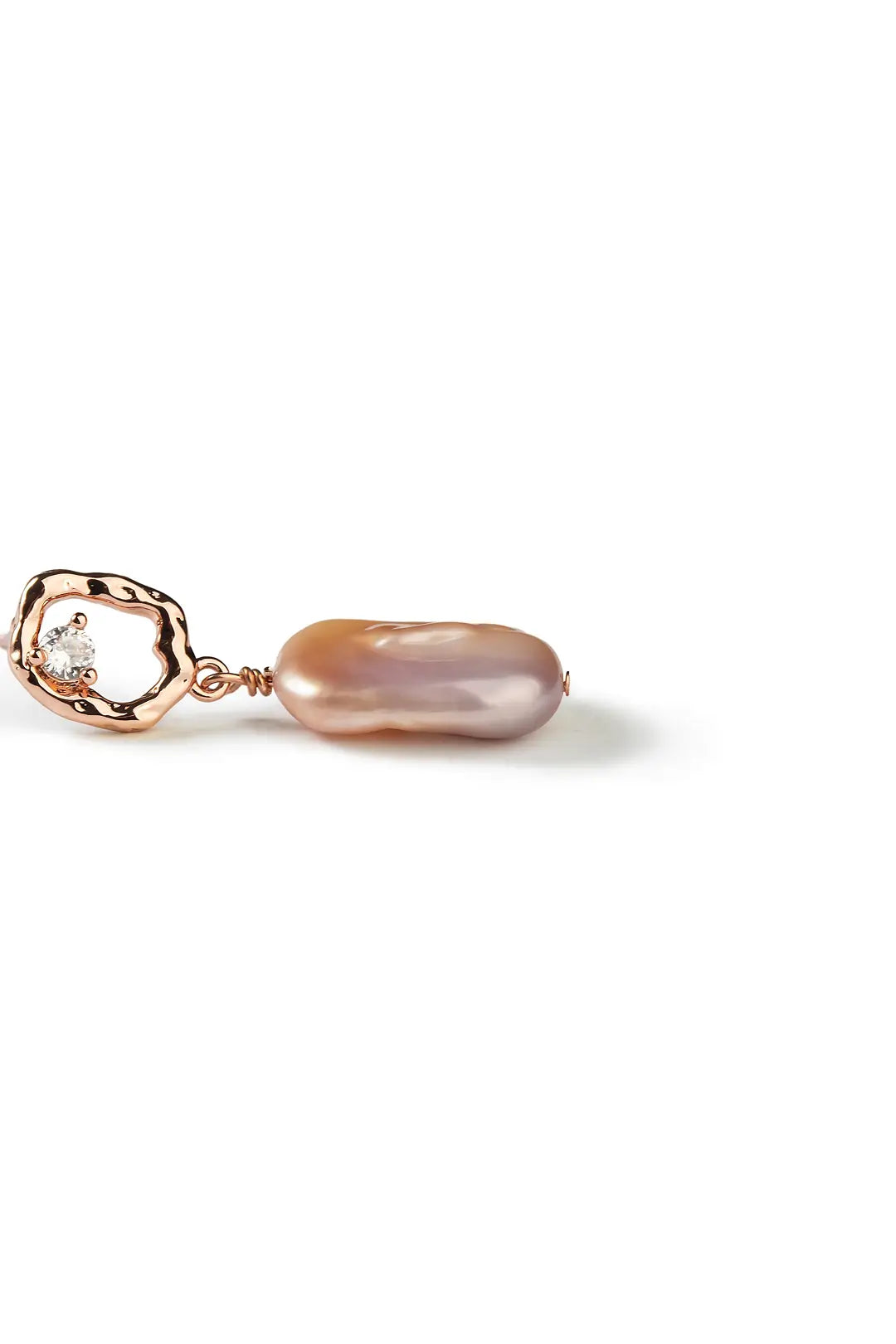 Aiko Tanaka Nagori earring side view, an irregular baroque pearl hanging from a rose gold link, white background