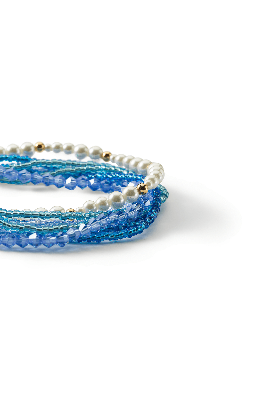 Aiko Tanaka Nami bracelet close-up, layered strands of blue beads and tiny white pearls, shown on a white background