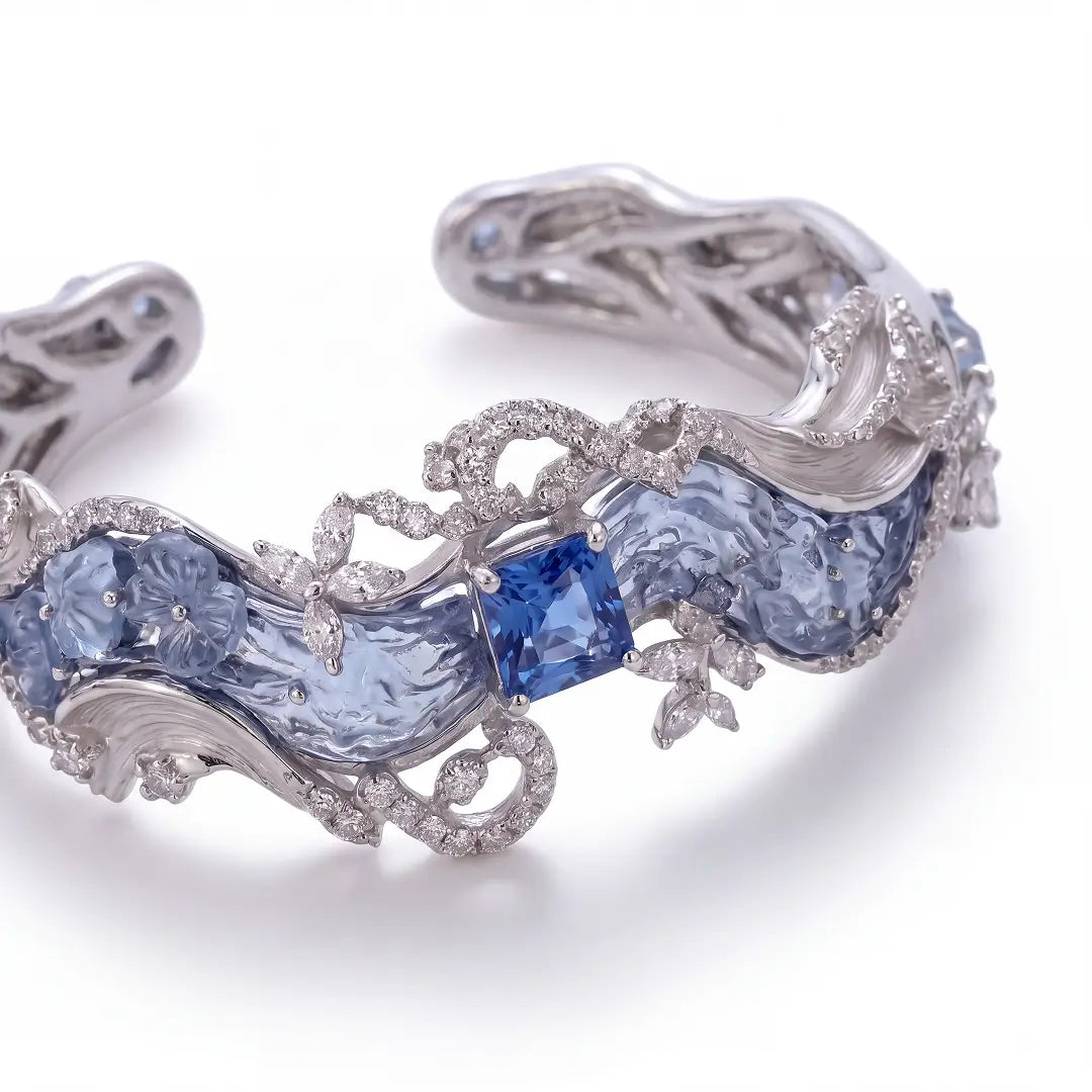 Aiko Tanaka High Jewelry No. 002 cuff, a silver wave bracelet with blue stones and crystal flowers, white background