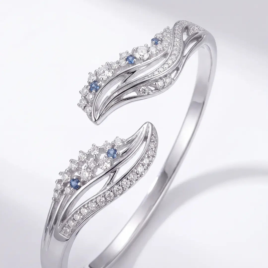 Aiko Tanaka High Jewelry No. 007 bracelet, an open silver cuff with crystal wave ends and blue stones, white background