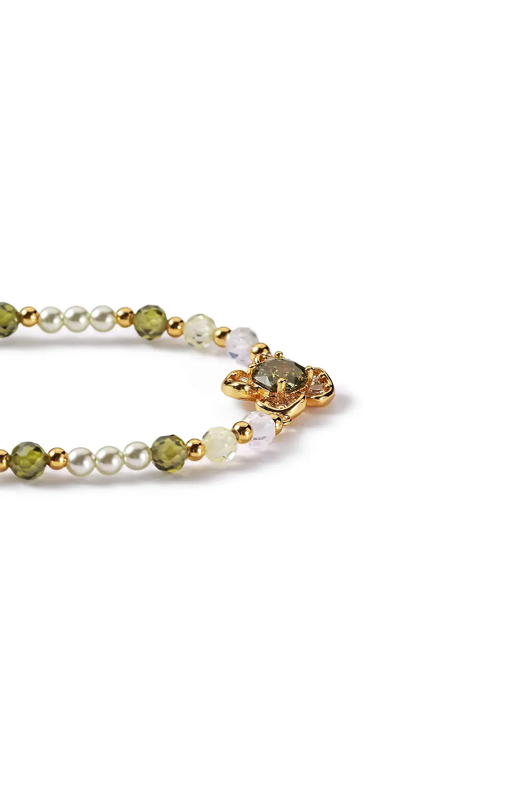 Aiko Tanaka Renka bracelet side view, pearls and green stones on a gold chain with a flower charm, on white