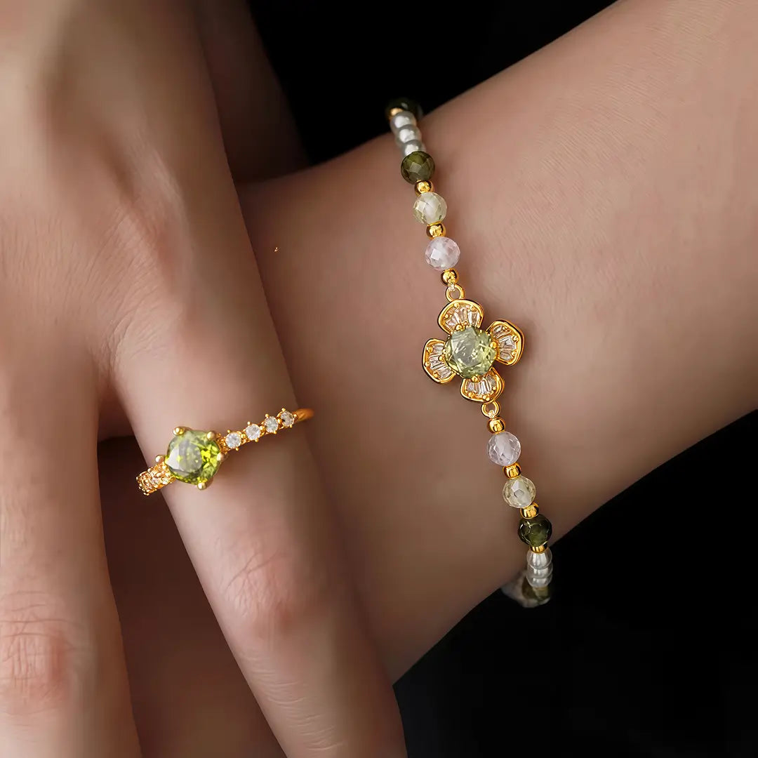 Aiko Tanaka Renka bracelet, pearls and a gold flower charm on the wrist, worn with a matching green stone ring