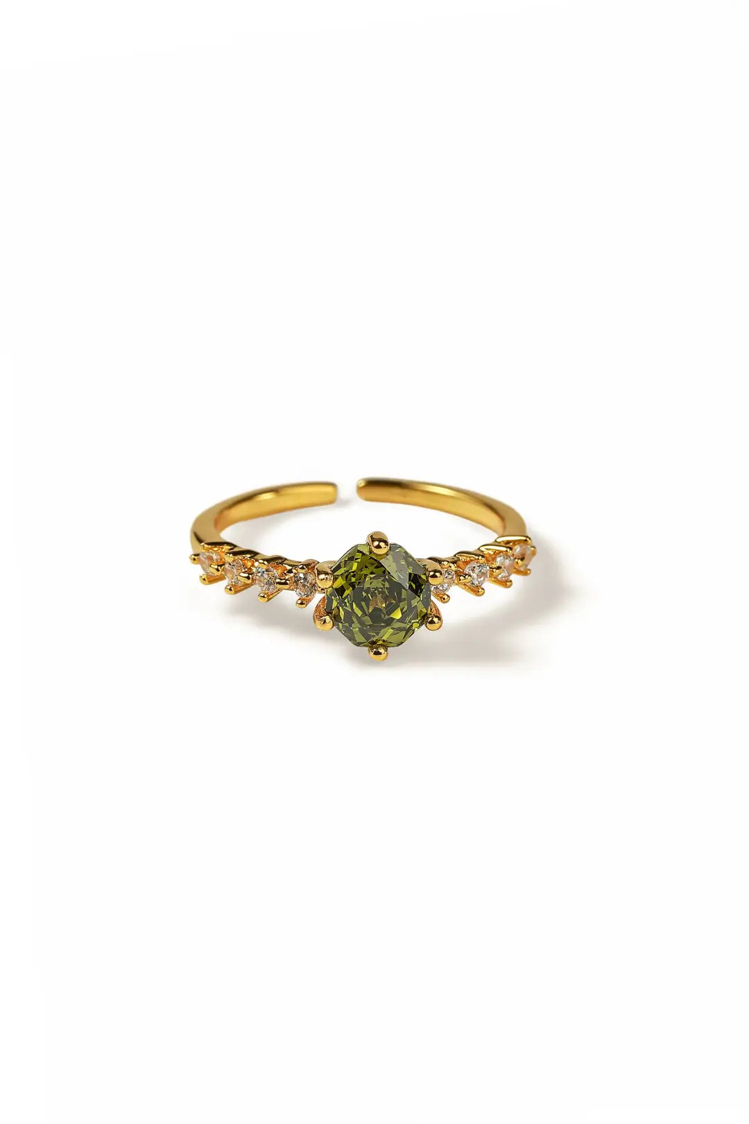 Aiko Tanaka Rensei ring, a gold open band with a hexagonal green stone and crystals, on a white background