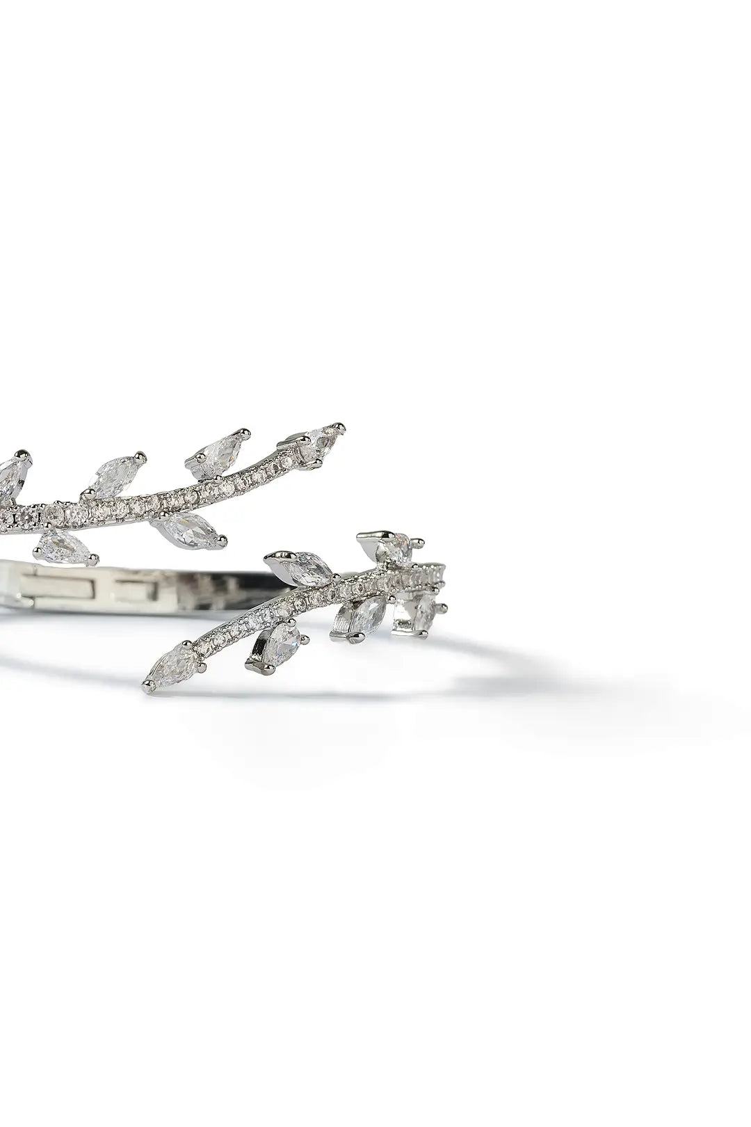 Aiko Tanaka Rinne bracelet close-up, a silver cuff shaped like a leafy branch set with crystals, white background