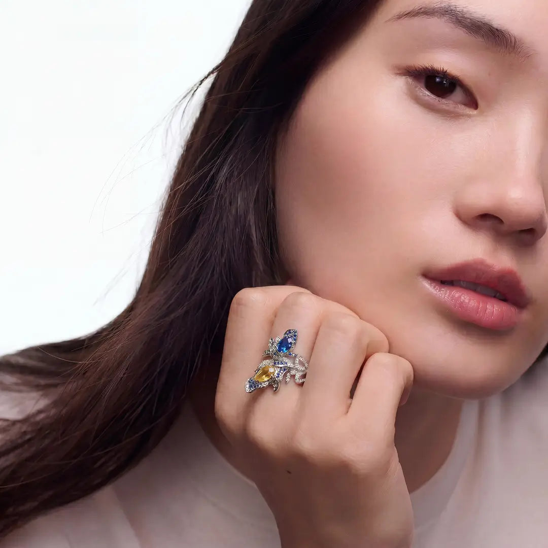 Young woman touching her face while wearing the Aiko Tanaka Seiran no Mai blue and yellow stone silver ring