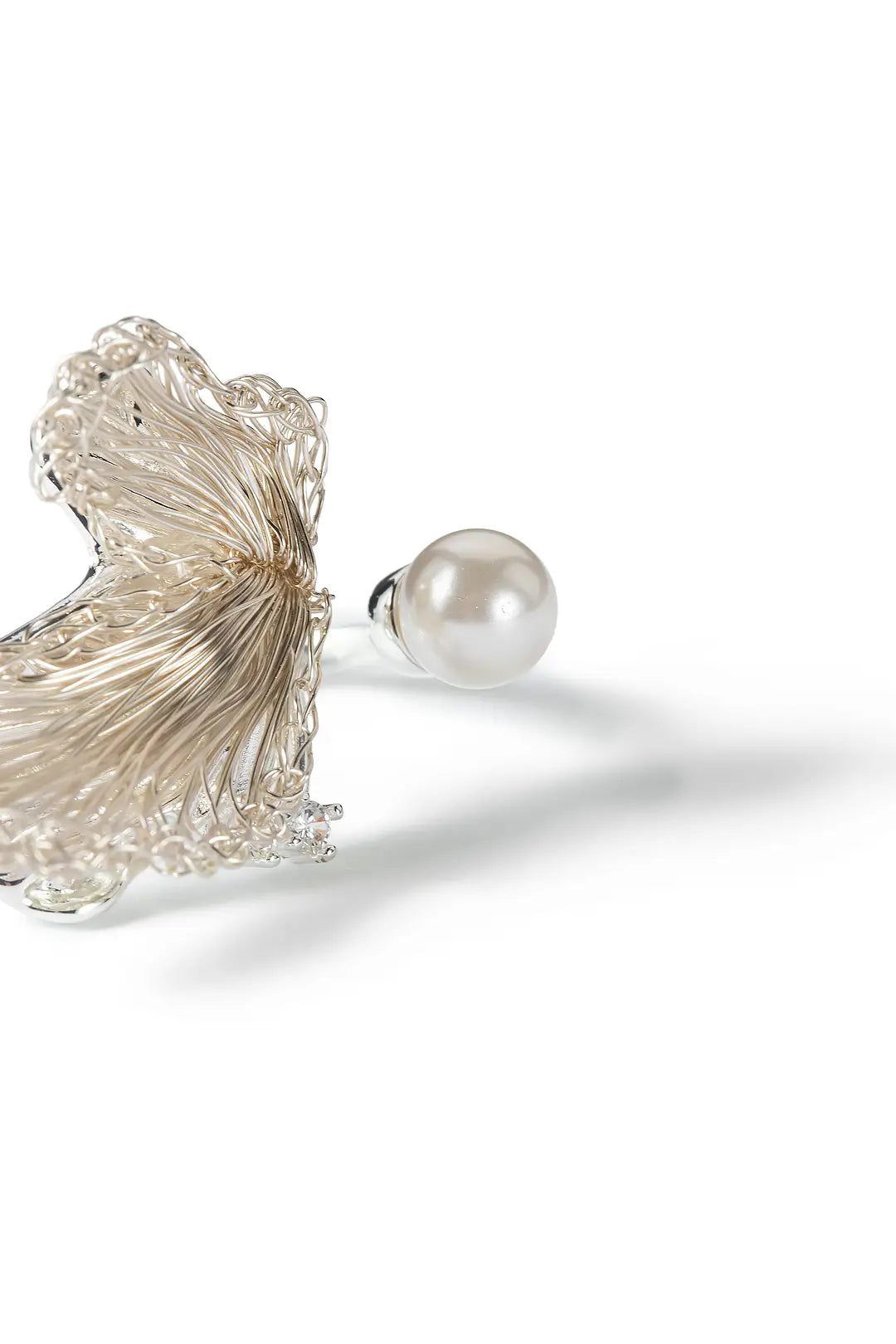 Aiko Tanaka Shiro Tsubasa ring close-up, a textured silver wing beside a white pearl on an open band, white background