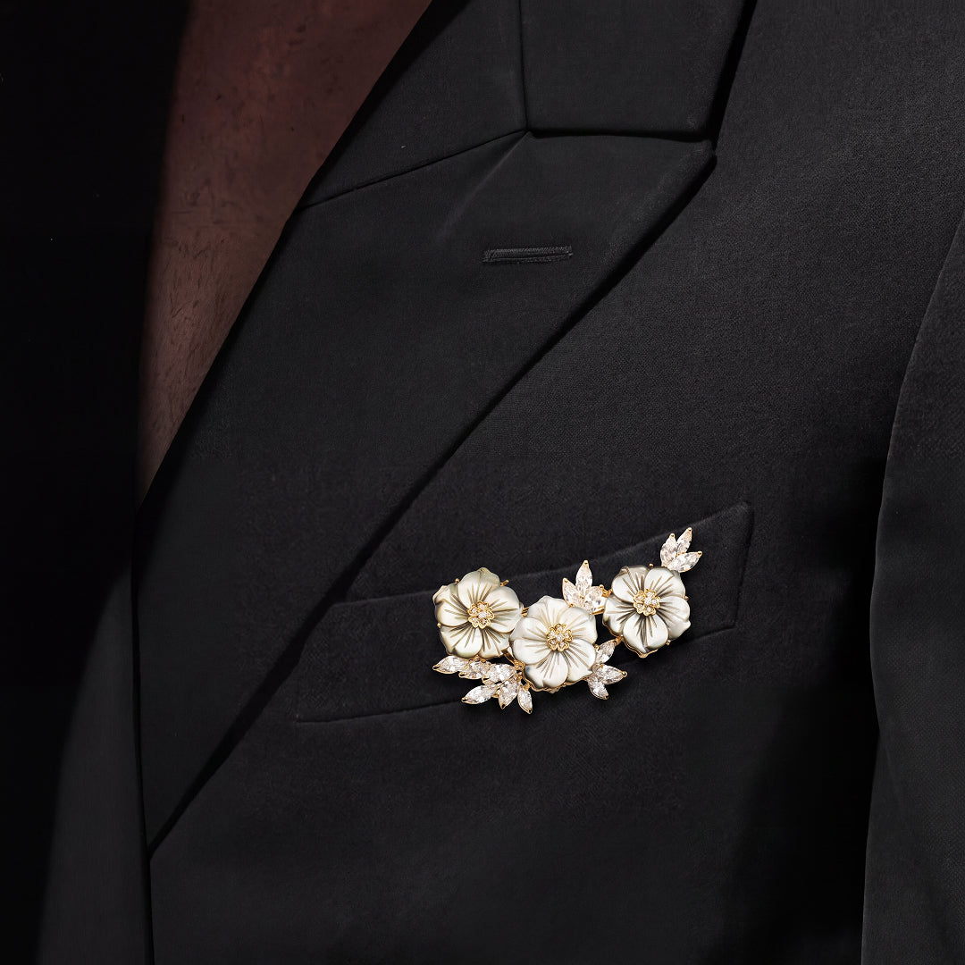 Black blazer lapel with the Aiko Tanaka Shirohana no Uta brooch, a spray of mother-of-pearl flowers and crystals