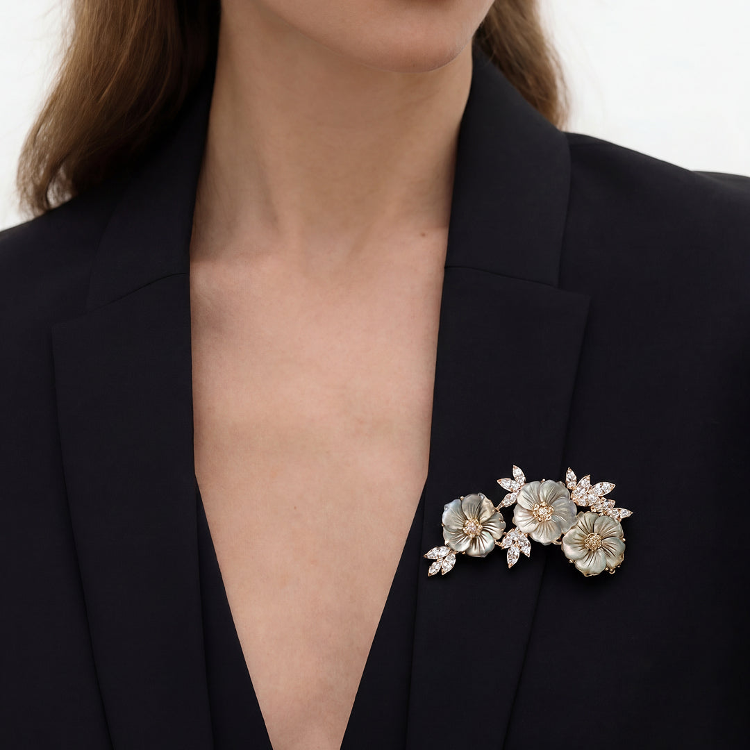 Woman in a black blazer wearing the Aiko Tanaka Shirohana no Uta white flower spray brooch on her lapel