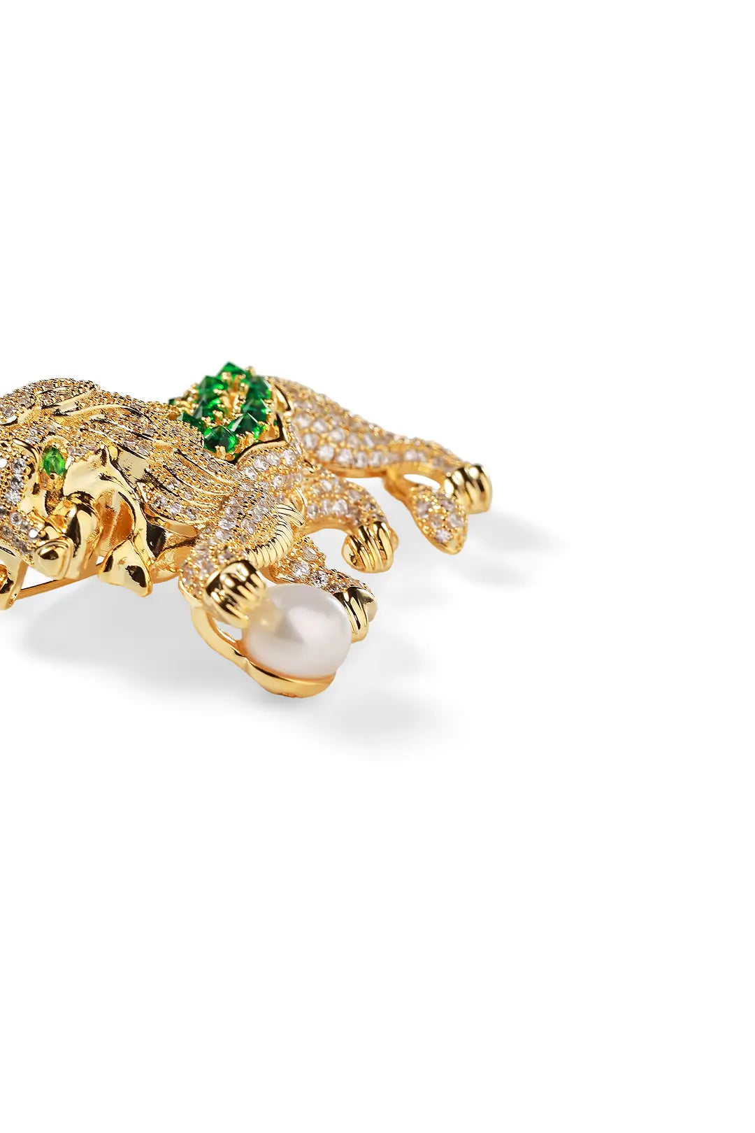 Aiko Tanaka Shishio brooch side view, a gold pavé lion with a green stone mane and a white pearl, on white