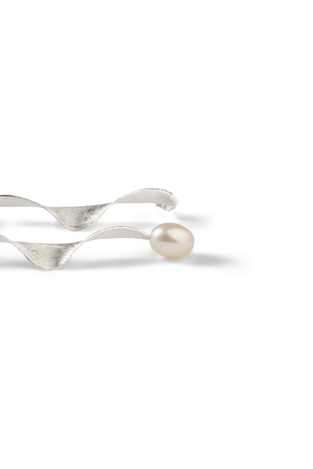 Aiko Tanaka Shizuku earring side view, a silver ribbon twist with a white pearl at the end, on a white background