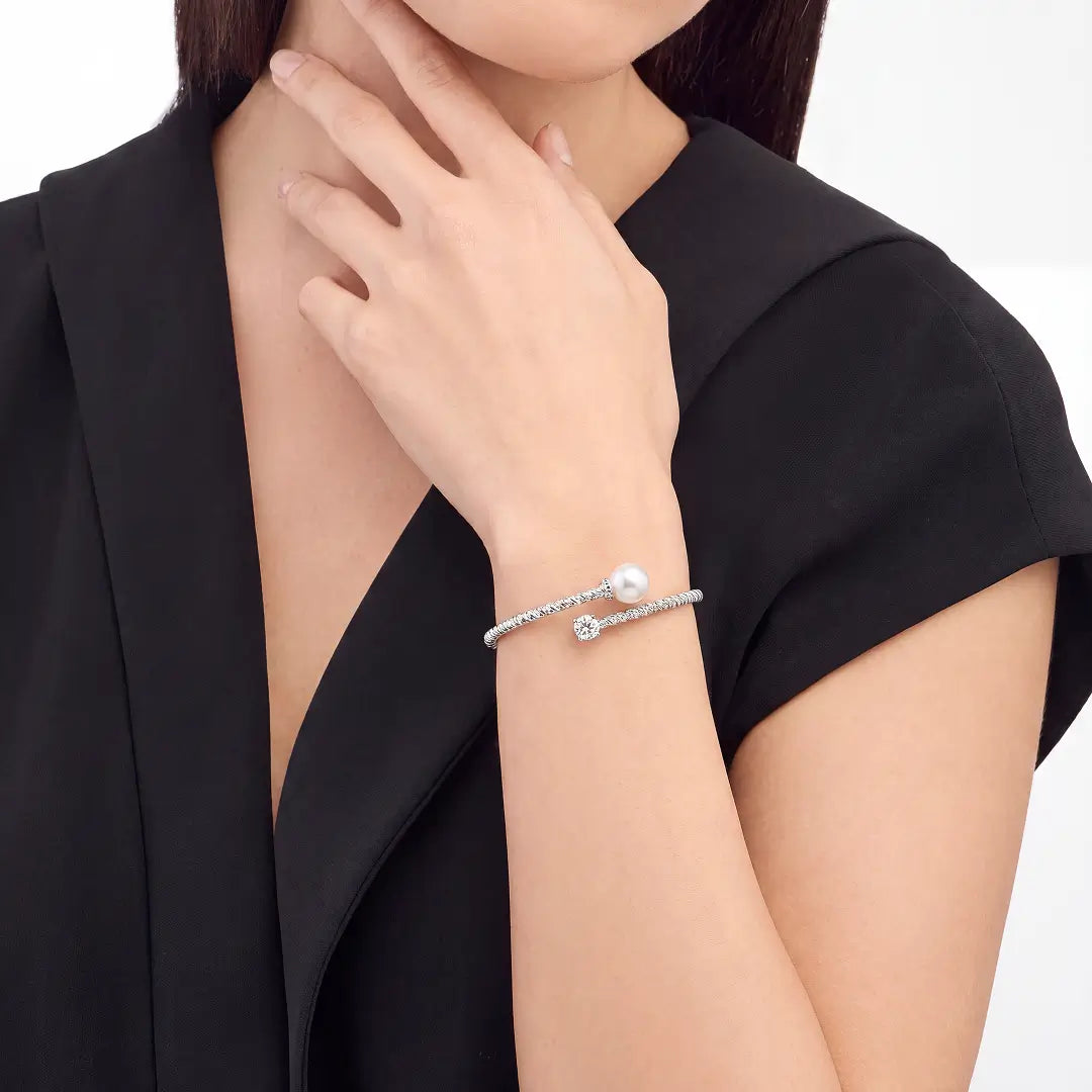 Aiko Tanaka Tsunagu bracelet worn on the wrist, a silver crystal cuff with a pearl, hand resting at the waist