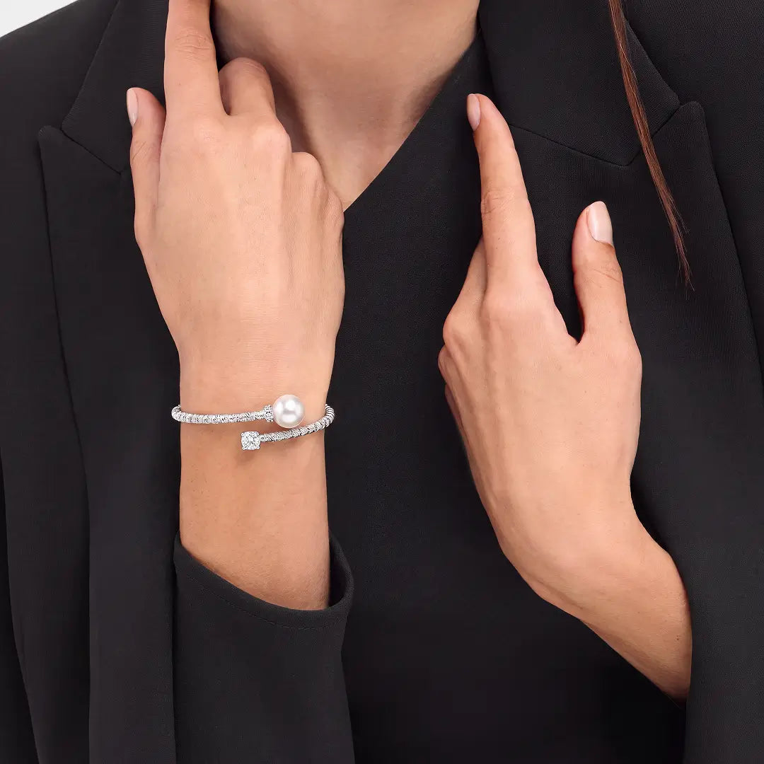 Aiko Tanaka Tsunagu bracelet, a silver crystal cuff with a pearl, worn on the wrist with a black top