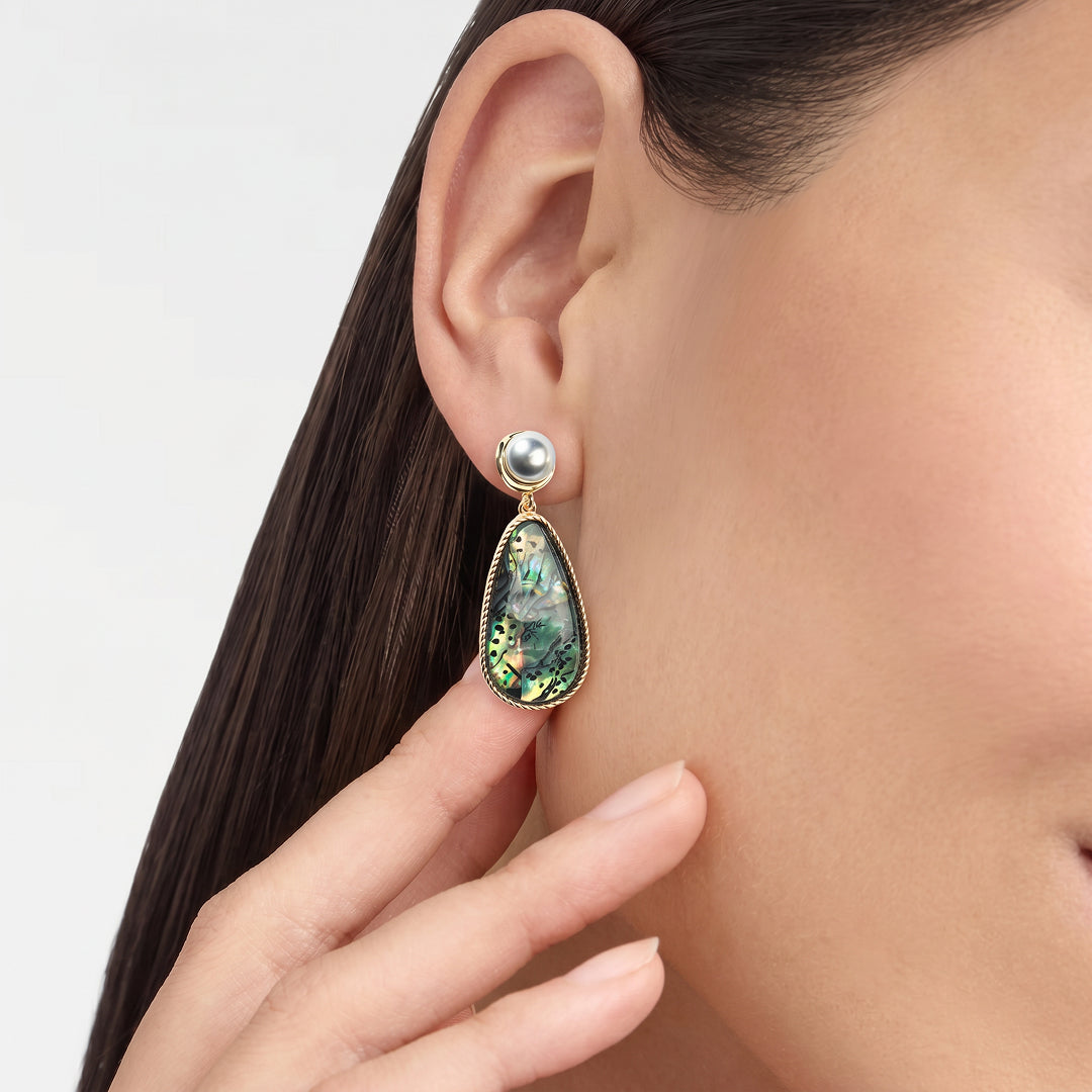 Woman touching her neck while wearing the Aiko Tanaka Umi no Kagami abalone teardrop earring with a pearl top