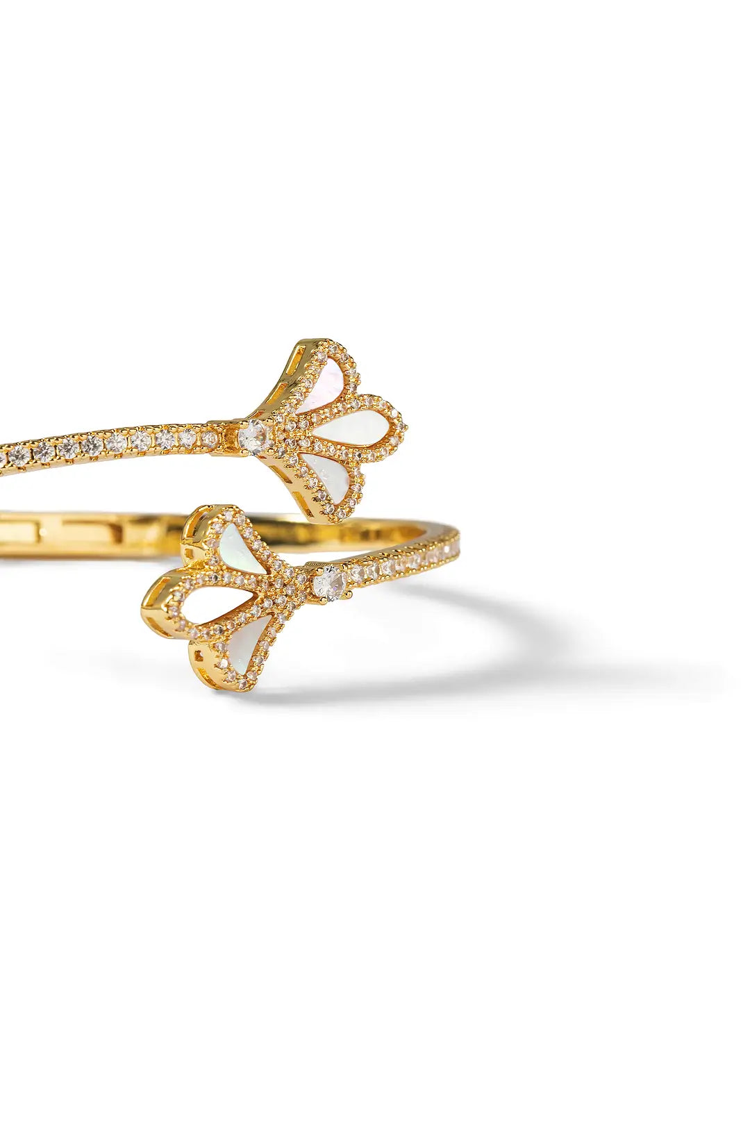 Aiko Tanaka Yohaku bracelet close-up, a gold cuff with crystal-set ginkgo leaf ends on a white background