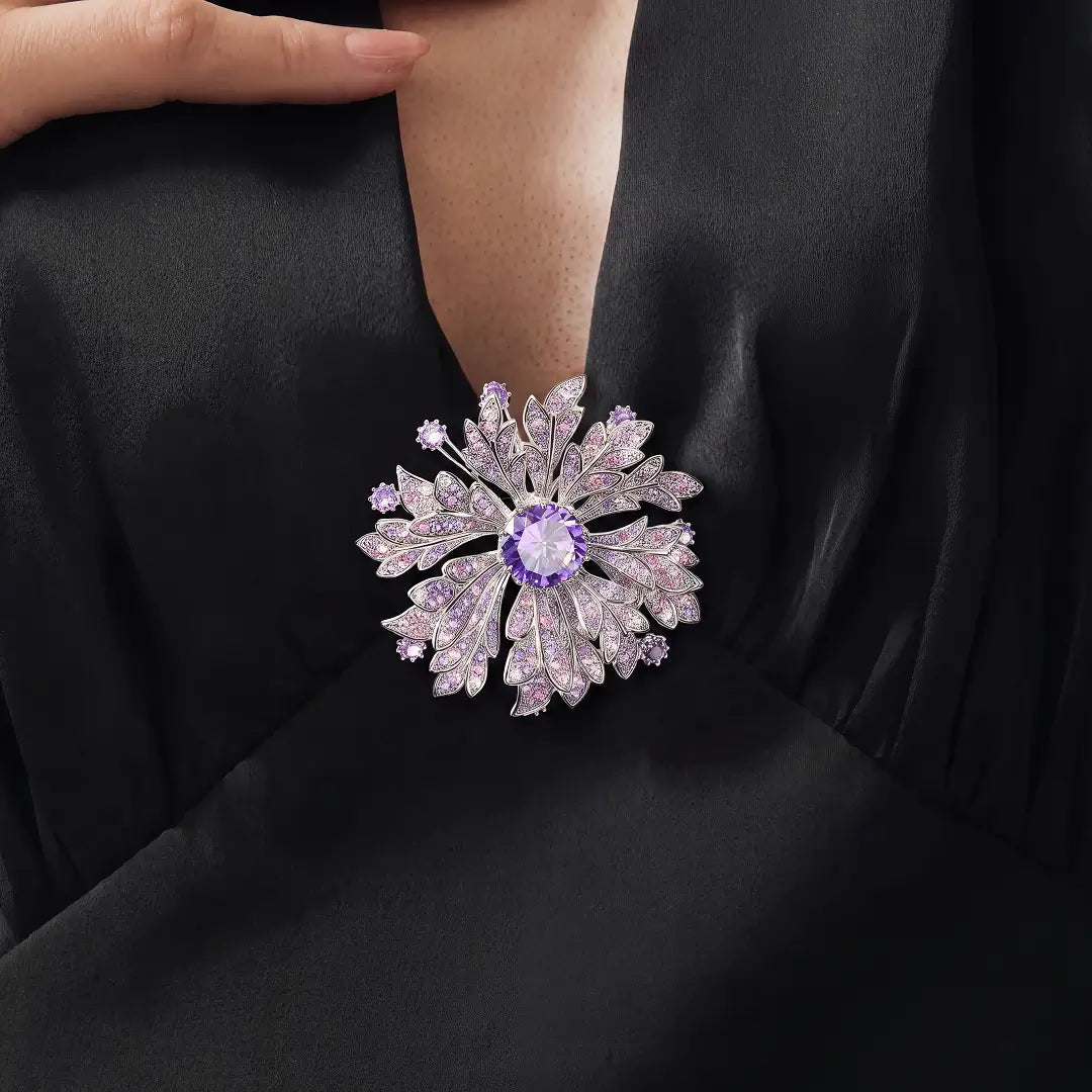 Aiko Tanaka Yozakura brooch, a lilac crystal-petal flower with a violet stone, pinned to a black satin top