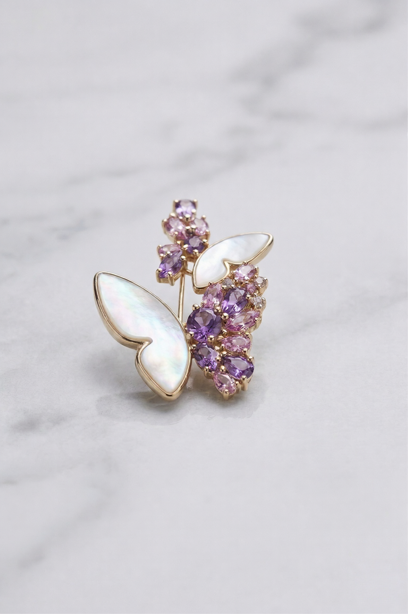 Aiko Tanaka Yume no Tsubasa butterfly brooch with mother-of-pearl wings and purple crystal blooms on white marble